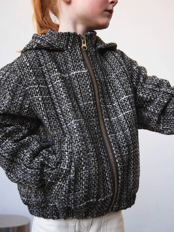 Stylish black and white textured jacket with a hood, perfect for kids, featuring a zip closure and side pockets by MEOTINE.