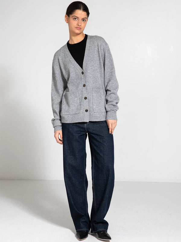 A model showcases a cozy gray cardigan with buttons and pockets, paired with loose dark jeans, embodying MEOTINE's relaxed style.