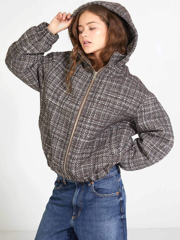 Stylish woman in a cozy, oversized plaid jacket with a hood, paired with denim jeans, showcasing MEOTINE's chic design.