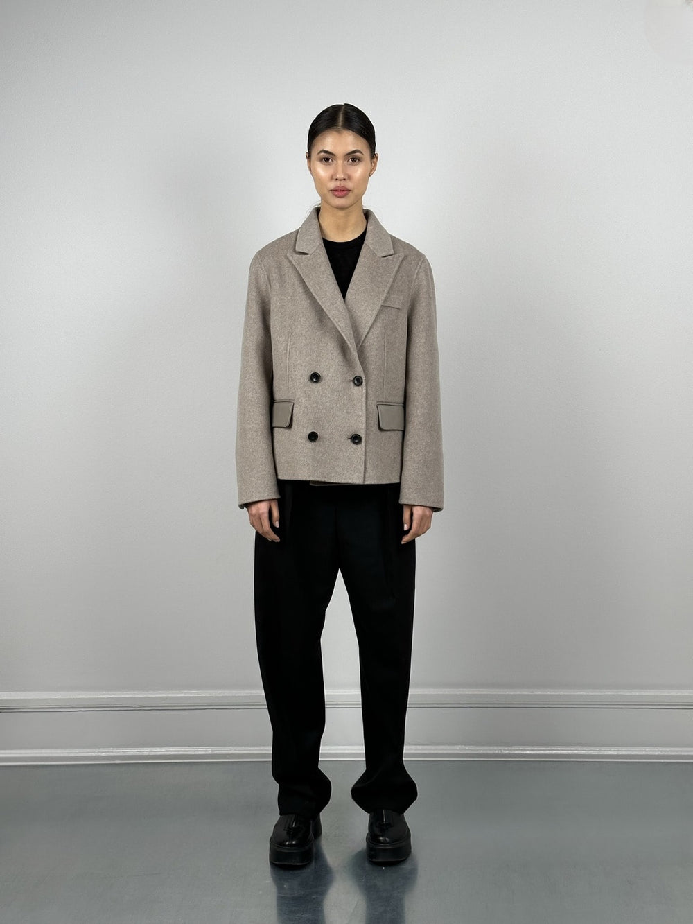 Stylish beige double-breasted coat with black buttons and sleek pockets, perfect for a chic look by MEOTINE.