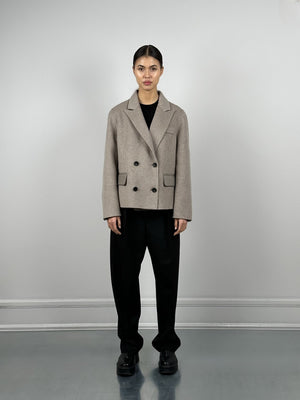 A model wears a stylish beige double-breasted jacket paired with black wide-leg trousers, showcasing MEOTINE's modern aesthetic.
