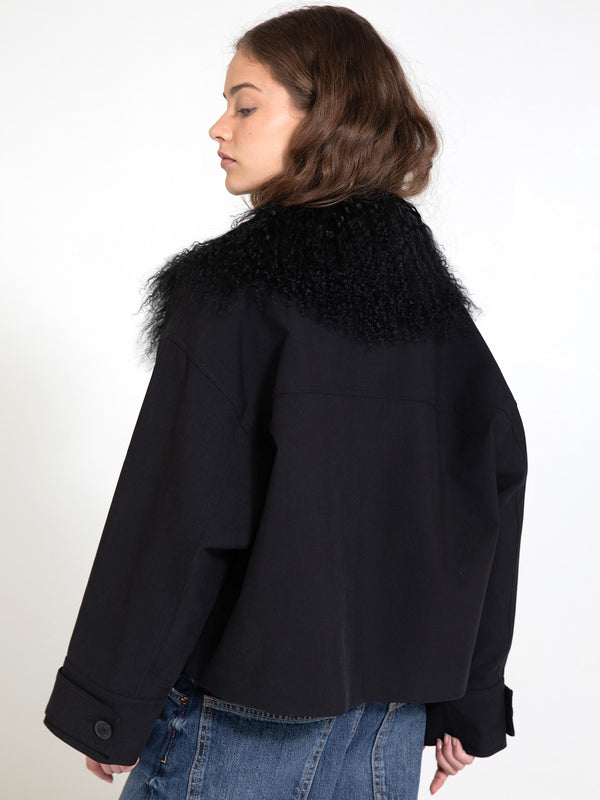 A model showcases a stylish black jacket with a fluffy collar, embodying MEOTINE's chic and modern aesthetic.