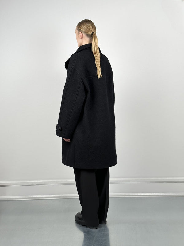 A model showcases a stylish black oversized coat from MEOTINE, featuring a relaxed fit and a classic collar, viewed from the back.