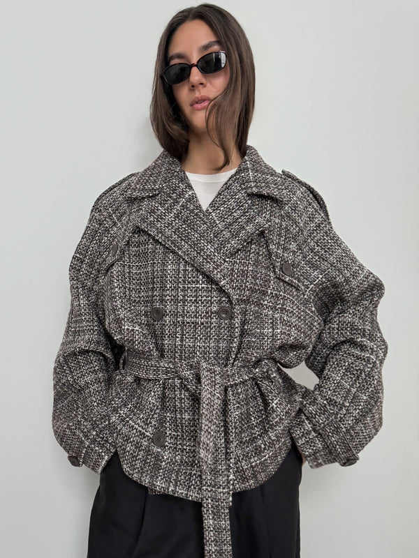 A model wears a stylish oversized gray and black textured jacket with a belt, showcasing a modern look by MEOTINE.