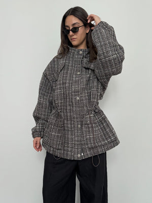 A model showcases a stylish, oversized MEOTINE jacket with a textured pattern, paired with black pants and sunglasses.