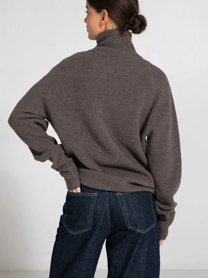 Cozy brown turtleneck sweater from MEOTINE, featuring a relaxed fit and ribbed texture, paired with dark denim jeans.