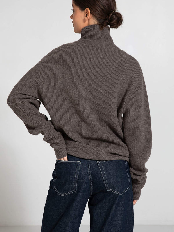 Cozy brown turtleneck sweater from MEOTINE, featuring a relaxed fit and ribbed texture, paired with dark denim jeans.