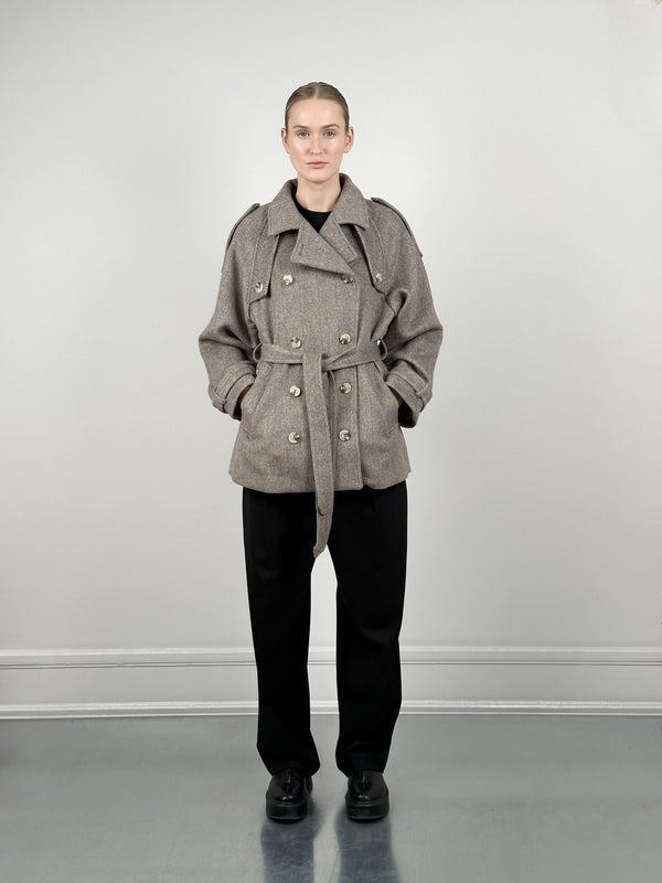 A model showcases a stylish gray double-breasted coat with a belt, paired with black trousers, representing MEOTINE's chic aesthetic.