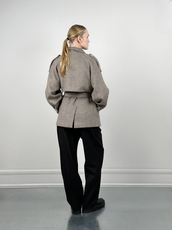 A model wearing a stylish beige oversized jacket with a belted waist, paired with black trousers, showcasing MEOTINE's chic design.