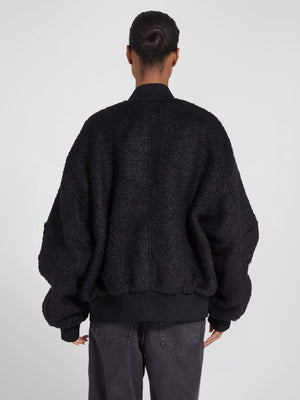 Oversized black bomber jacket with a textured finish, featuring a relaxed fit and ribbed cuffs, by MEOTINE.