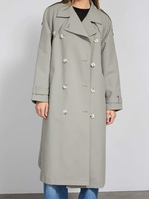 A stylish light gray trench coat with double-breasted buttons, perfect for a chic look by MEOTINE.