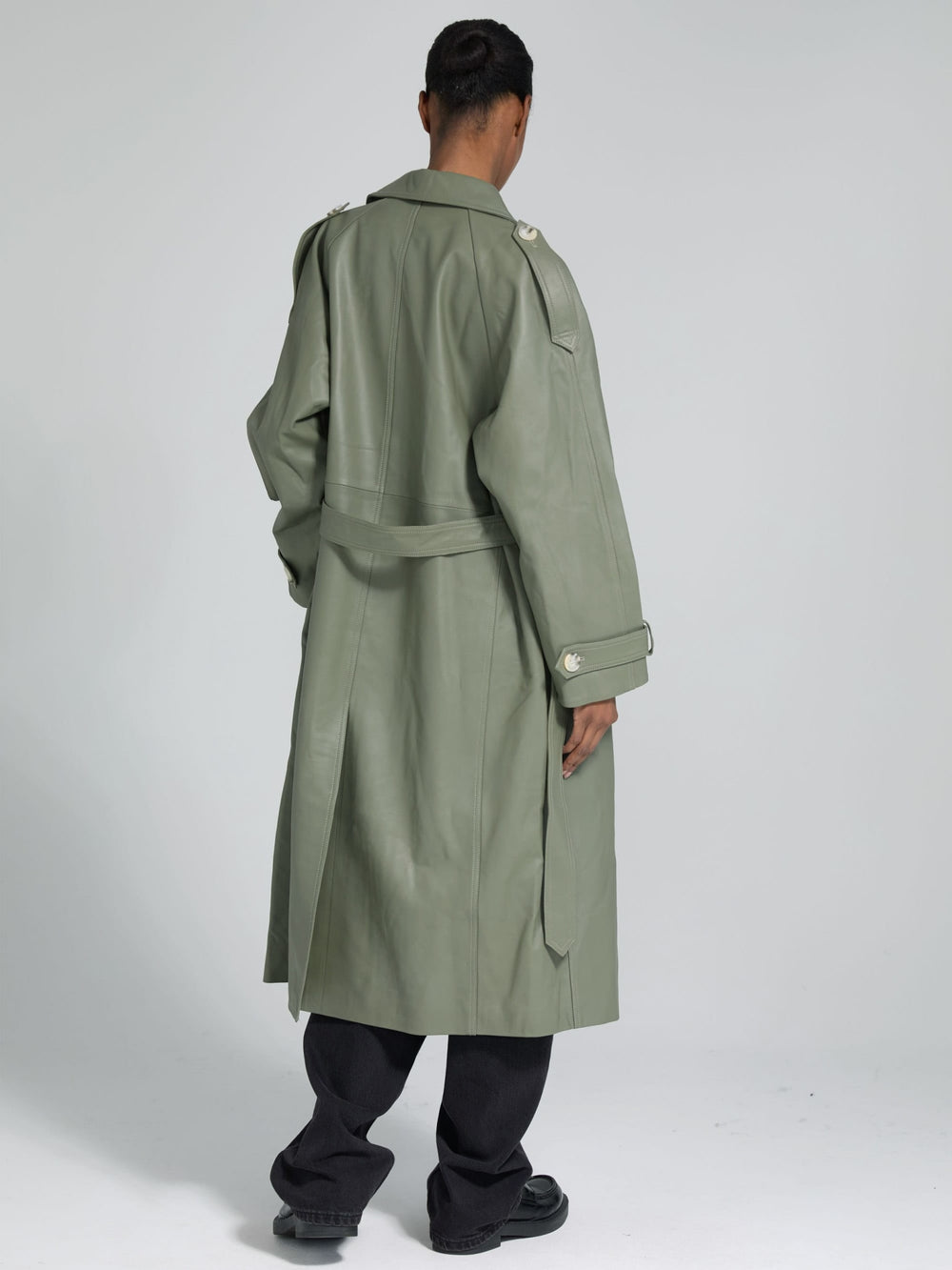 A model showcases a stylish oversized green trench coat by MEOTINE, paired with a simple white top and black trousers.