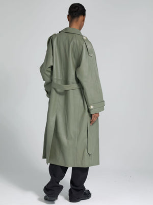 A model showcases a stylish olive green trench coat from MEOTINE, featuring a belted waist and shoulder epaulets, viewed from the back.