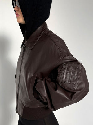 Stylish brown leather bomber jacket with a relaxed fit, featuring a zip pocket and ribbed cuffs, perfect for a trendy look by MEOTINE.