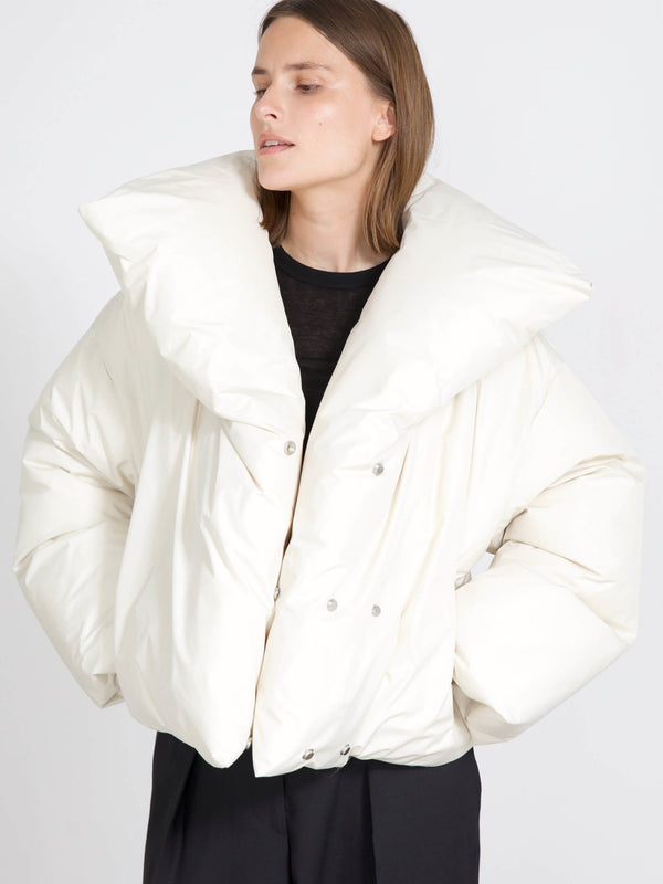 A model wears a stylish oversized white puffer jacket with a dramatic collar, showcasing MEOTINE's modern winter fashion.