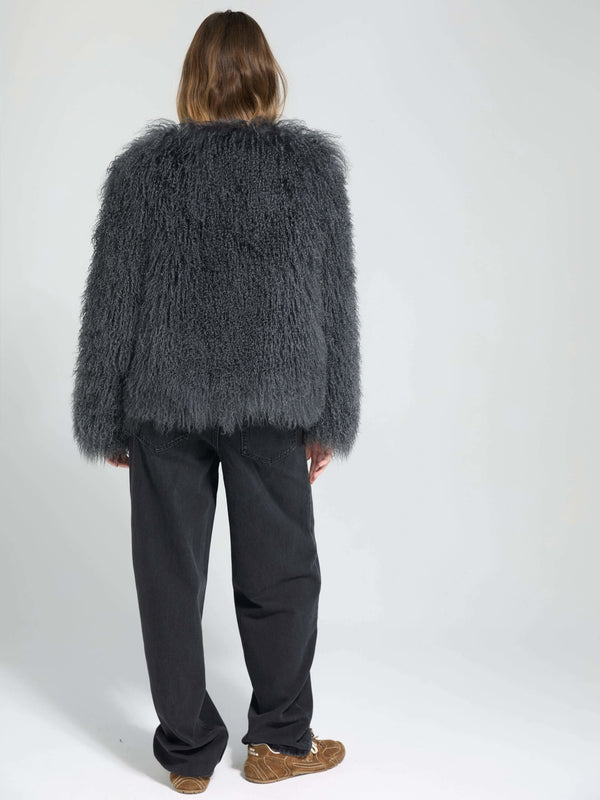 A model wearing a fluffy gray MEOTINE jacket paired with loose black pants, showcasing a stylish and cozy look from the back.