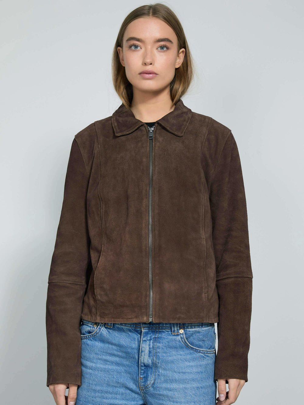 Brown suede jacket with a zip closure and collar, styled with blue jeans, showcasing a modern and chic look by MEOTINE.