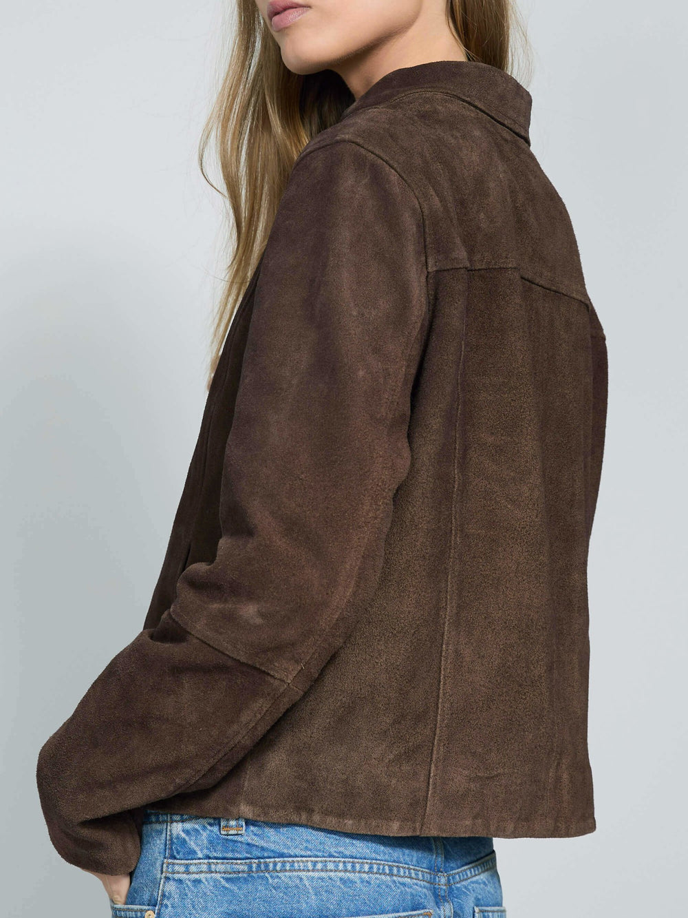 Brown suede jacket with a zip closure and collar, styled with blue jeans, showcasing a modern and chic look by MEOTINE.