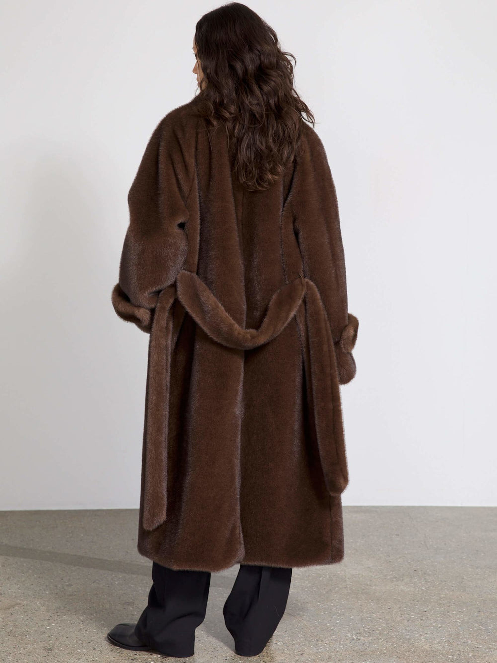 A model wearing a cozy brown faux fur coat over a black outfit, showcasing the stylish design of MEOTINE's outerwear.