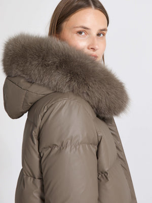 A woman models a stylish MEOTINE puffer jacket with a luxurious fur hood, showcasing a chic and cozy winter look.
