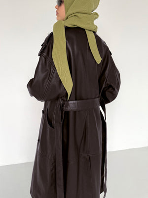 A model wearing a dark brown leather coat with a belted waist and an olive green scarf, showcasing MEOTINE's stylish design.