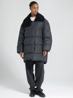 Stylish black puffer coat with a plush collar, worn by a model in casual attire, showcasing MEOTINE's modern winter fashion.