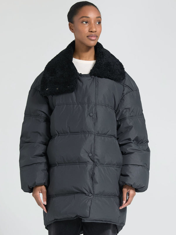 A woman models a cozy black puffer jacket with a plush collar, showcasing MEOTINE's stylish and warm winter outerwear.