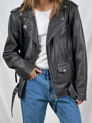 Stylish black leather biker jacket with silver zippers, paired with a white top and blue jeans, showcasing MEOTINE's edgy design.