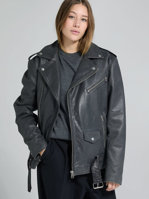 Stylish black leather jacket with a classic biker design, worn by a model, showcasing MEOTINE's edgy fashion aesthetic.