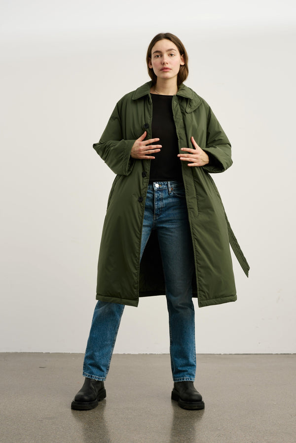 A model wearing a long olive green puffer coat over a black top and blue jeans, showcasing MEOTINE's stylish outerwear.