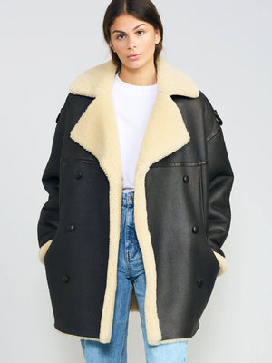 Oversized black coat with a soft beige shearling collar and lining, featuring a relaxed fit and button details. MEOTINE brand style.