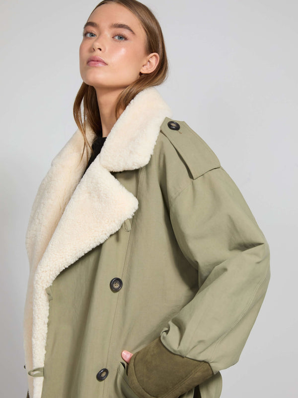 A model showcases a stylish olive green coat with a plush cream collar, embodying MEOTINE's chic and cozy aesthetic.