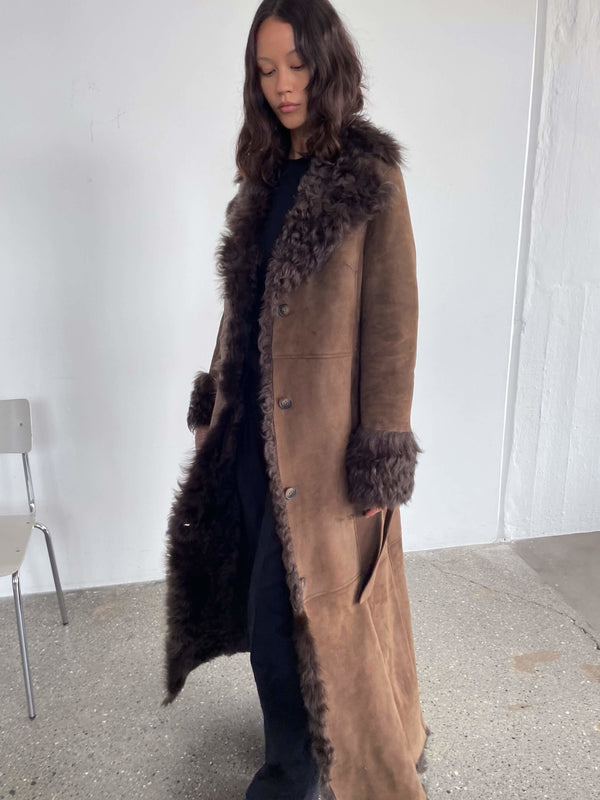 A model showcases a stylish brown coat with a fur collar and cuffs, embodying elegance and warmth, perfect for winter by MEOTINE.