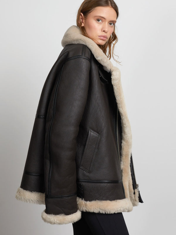 Stylish black shearling jacket with a cozy fur collar, perfect for a chic winter look. MEOTINE offers warmth and elegance.