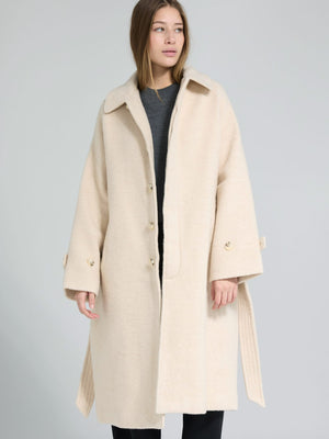 A model wears a stylish beige coat with a relaxed fit and large buttons, showcasing MEOTINE's elegant design.