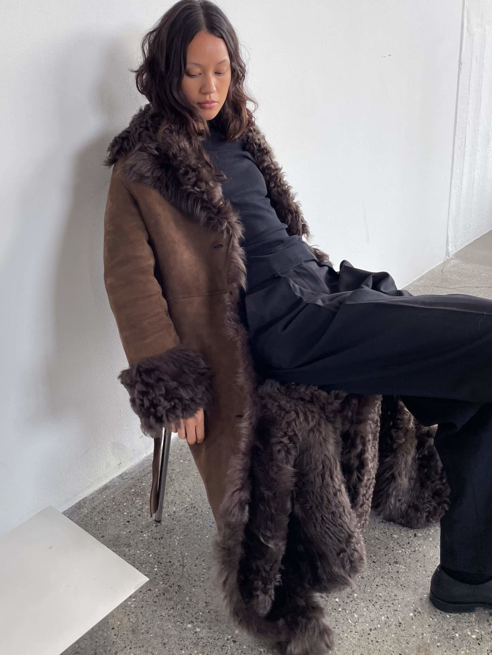 A model showcases a stylish brown coat with a fur collar and cuffs, embodying MEOTINE's chic and cozy aesthetic.
