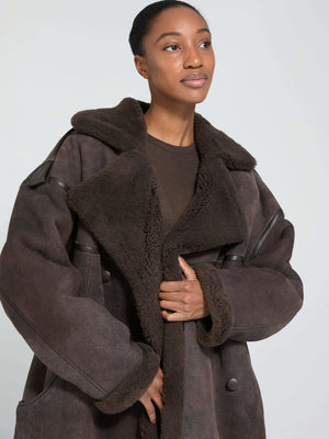 A model showcases a cozy, oversized brown shearling coat with a wide collar, embodying MEOTINE's stylish warmth and comfort.