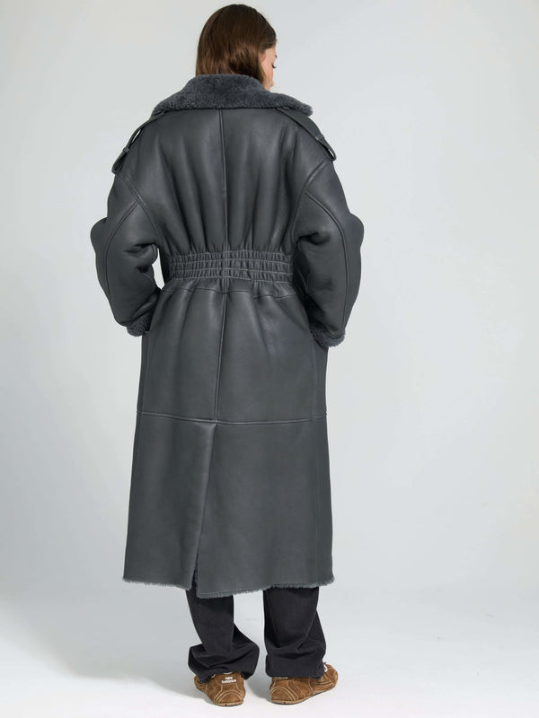 A model wearing a stylish gray MEOTINE coat with a plush collar, showcasing a relaxed fit and cinched waist from the back.