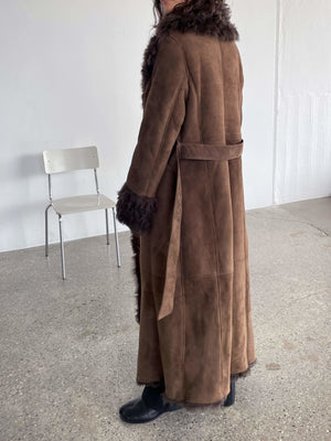 A model showcases a luxurious brown suede coat with a fur collar and cuffs, embodying elegance and warmth by MEOTINE.