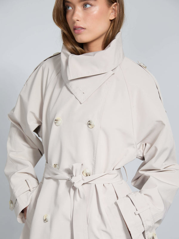 Stylish beige trench coat with a high collar and belt, perfect for a chic look. Designed by MEOTINE for modern elegance.