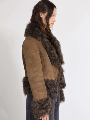 Brown suede jacket with a fluffy fur collar and cuffs, showcasing a stylish side profile. Perfect for a chic winter look by MEOTINE.