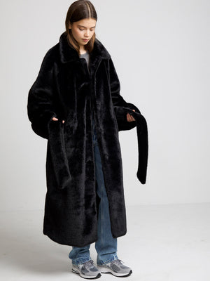 Cozy black faux fur coat by MEOTINE, featuring a wide collar and long sleeves, perfect for stylish warmth in colder weather.