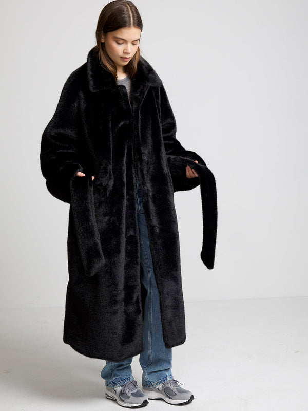 Cozy black faux fur coat by MEOTINE, featuring a wide collar and long sleeves, perfect for stylish warmth in colder weather.