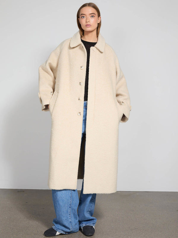 A model wearing a cozy beige oversized coat with a collar, paired with loose blue jeans, showcasing MEOTINE's stylish outerwear.