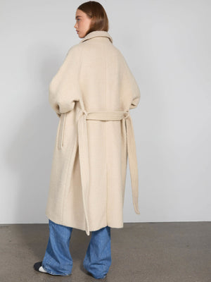 Cozy beige oversized coat with a belt, featuring a relaxed fit and soft texture, perfect for layering. By MEOTINE.