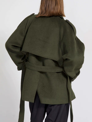 A model showcases a stylish olive green coat with a unique layered design and a belted waist, perfect for a chic look by MEOTINE.