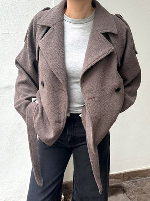 Stylish brown double-breasted jacket with a relaxed fit, paired with a light gray top and black jeans, by MEOTINE.