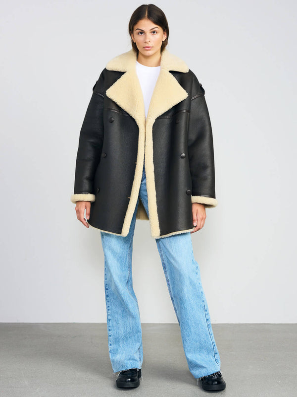 Oversized black coat with a plush cream collar and cuffs, paired with light blue jeans, showcasing MEOTINE's stylish design.