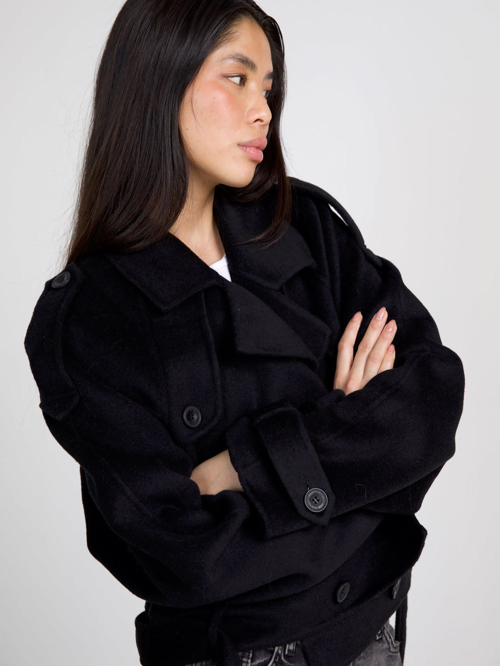 A model wears a stylish black cropped coat with a double-breasted design, paired with gray jeans, showcasing MEOTINE's chic aesthetic.