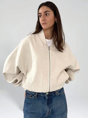 A model showcases a stylish beige oversized bomber jacket by MEOTINE, paired with a simple white tee and denim jeans.